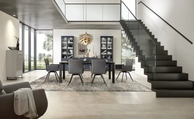 Sie sehen ein Esszimmer mit hohen Vitrinen. Sehr Moderne Einrichtung mit dunklen Farben